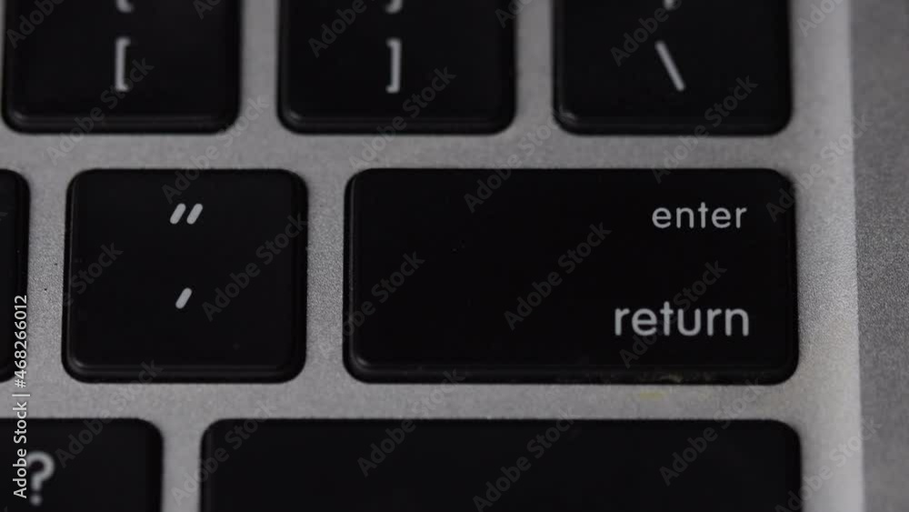 Finger pressing enter - return key on keyboard. Macro view Finger pressing enter - return key on keyboard. Macro view