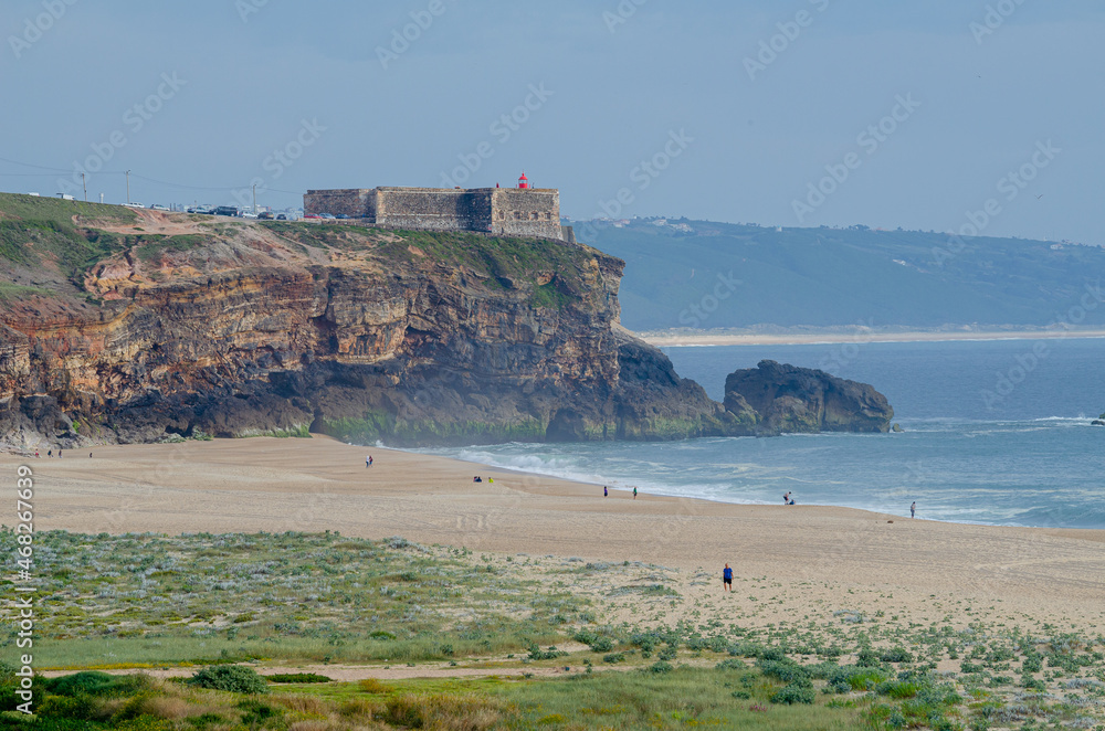 Praia do Norte beach, cliffs and Nazaré lighthouse cape.Portugal.