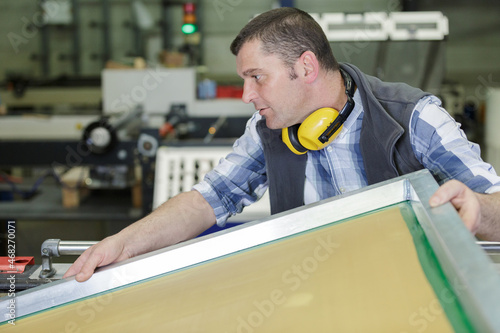 Obraz na plátne workman lifting awkward object in a factory