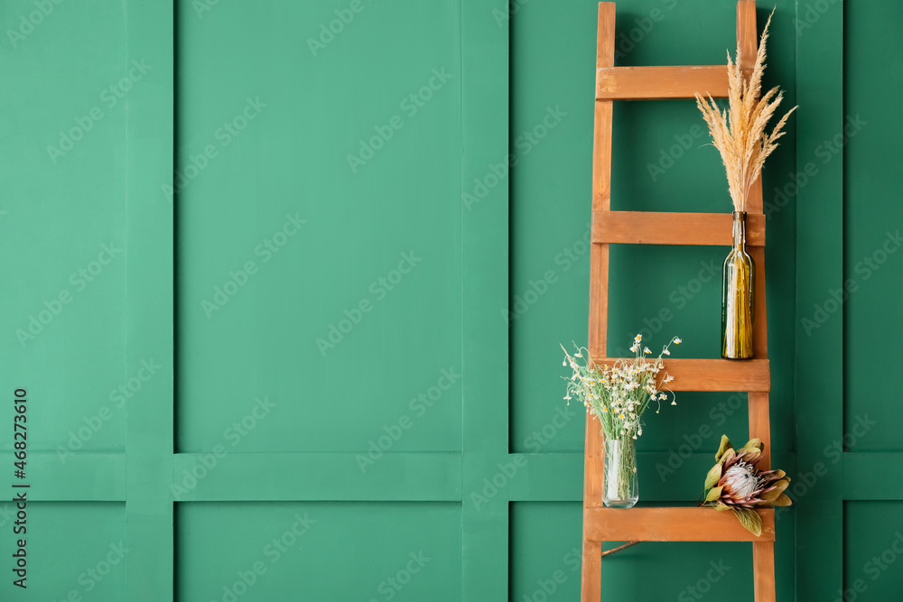 Vases with dried flowers on ladder near color wall - obrazy, fototapety, plakaty 