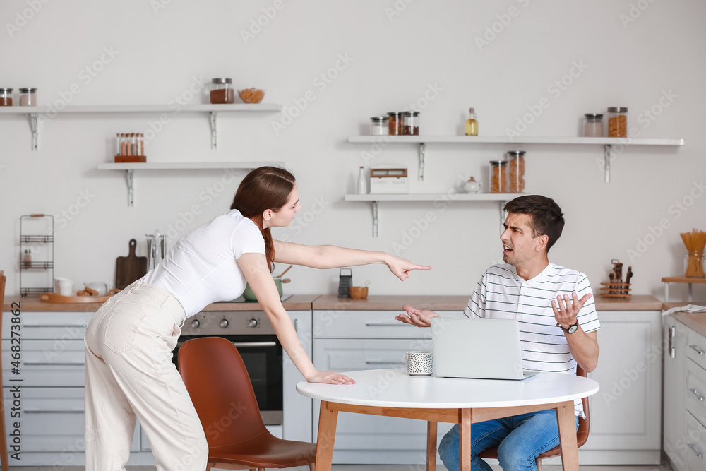 Young couple arguing in kitchen Young couple arguing in kitchen