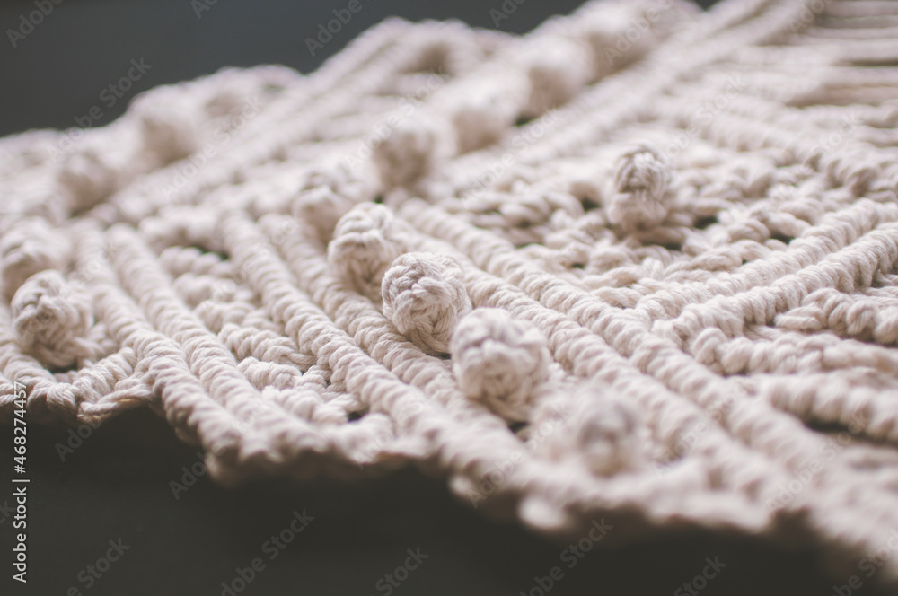 Macrame ornament from white natural cotton threads on a black background Macrame ornament from white natural cotton threads on a black background