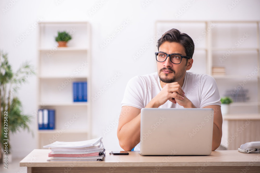 Young male student employee at workplace Young male student employee at workplace