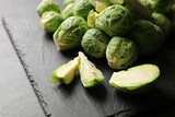 Slate plate with fresh Brussels cabbage on dark background, closeup
