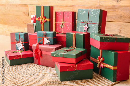 Many Christmas gifts near wooden wall