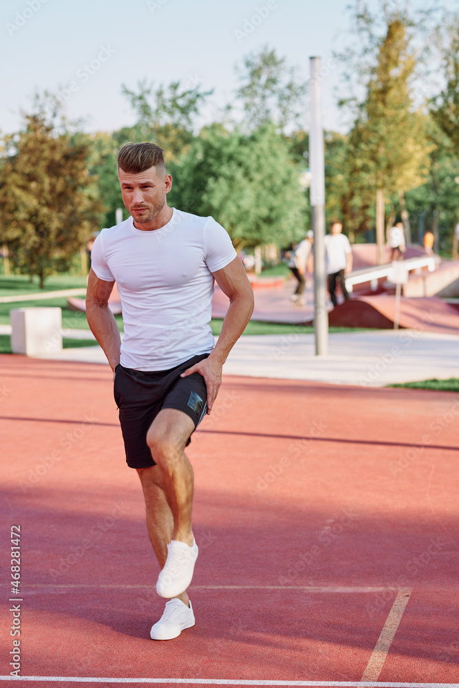 athletic men doing exercises on the sports ground in summer
