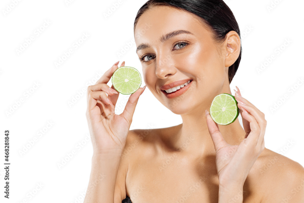 Beautiful young woman holding lime halves near her face, healthy food concept, woman posing with citrus fruits Beautiful young woman holding lime halves near her face, healthy food concept, woman posing with citrus fruits