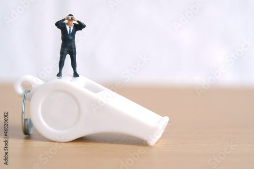 Businessmen using binoculars standing above whistle. Miniature tiny people toys photography. isolated on white background.