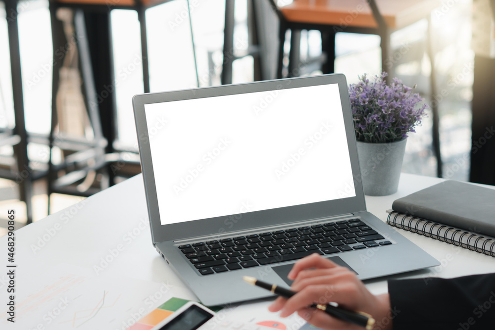 Businessman at a desk in an office typing on a laptop computer with blank white screen ready for content Businessman at a desk in an office typing on a laptop computer with blank white screen ready for content