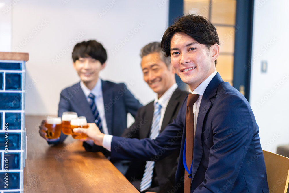 バーで乾杯をする3人の会社員