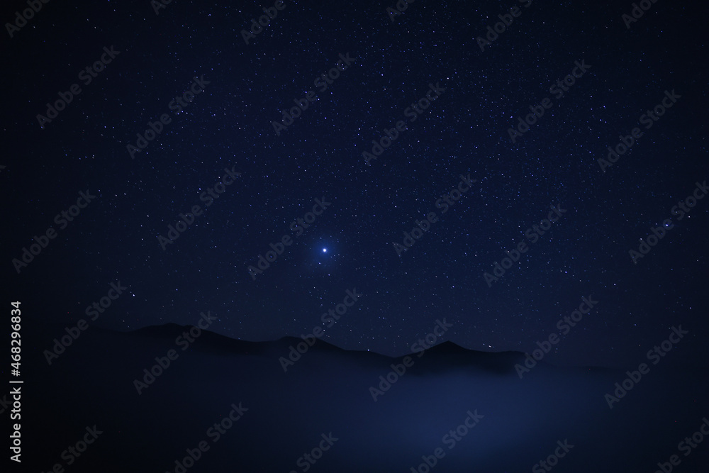 Beautiful view of misty mountains under starry sky at night