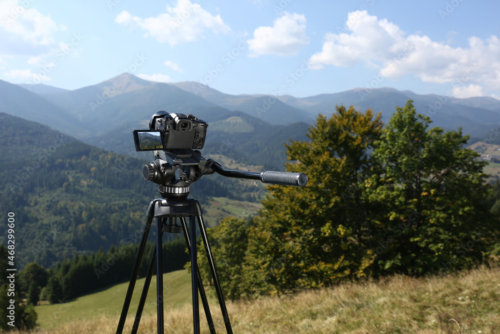 Tripod with modern camera in mountains on sunny day. Space for text Tripod with modern camera in mountains on sunny day. Space for text