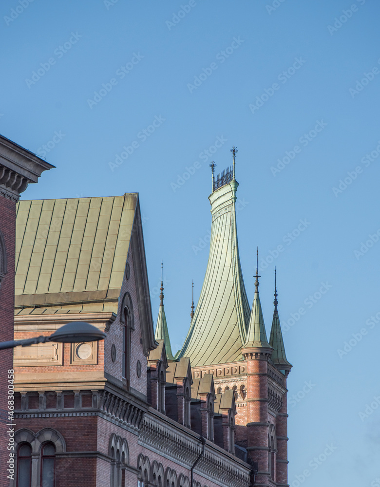Fototapeta premium Facade and Cooper Roof of a gothic brick building a sunny autumn day in Stockholm