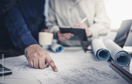 Architect working on blueprint. Architects workplace - architectural project, blueprints, ruler, calculator, laptop and divider compass. Construction concept. Blue print is fake only for stock photo. photo