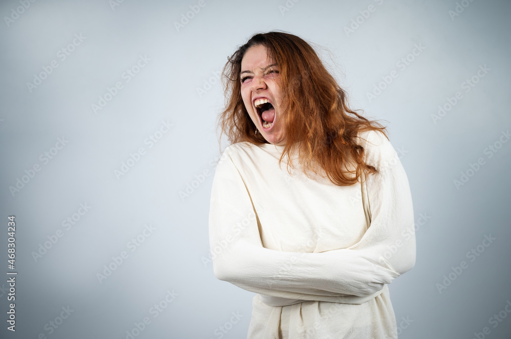 Close-up portrait of insane woman in straitjacket on white background. Close-up portrait of insane woman in straitjacket on white background.