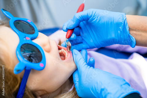 the dentist examines the teeth of a little girl at the reception. 