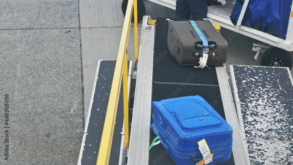 Luggage sliding on automatic conveyor into the plane Luggage sliding on automatic conveyor into the plane