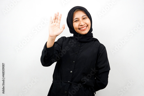 Beautiful and cheerful young asian muslim woman, with open palms, saying hello, how are you, isolated on white background