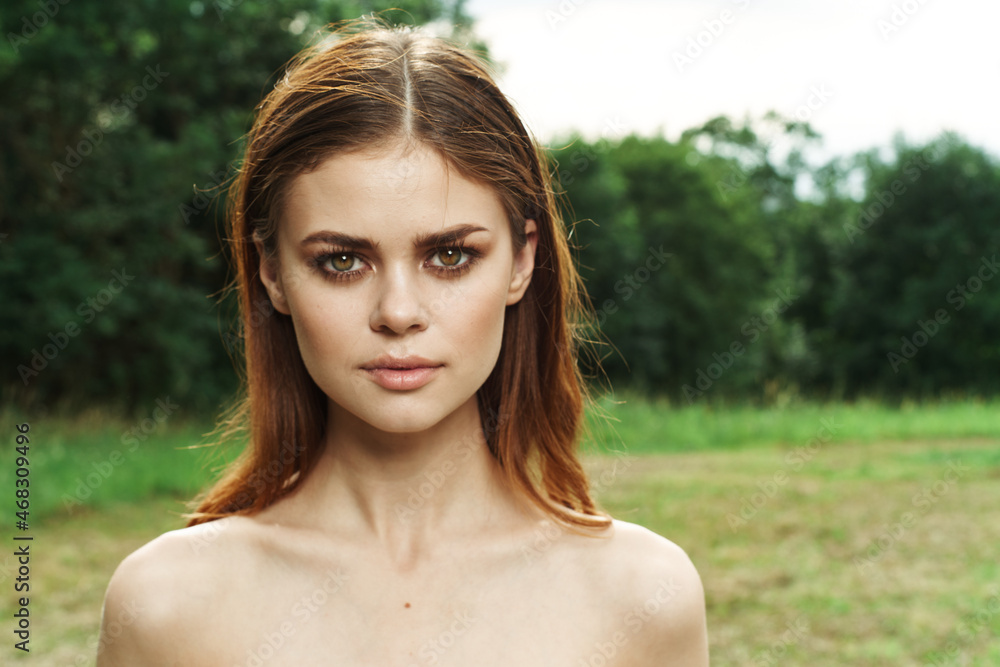 pretty woman in a field outdoors bare shoulders clear skin cropped view pretty woman in a field outdoors bare shoulders clear skin cropped view