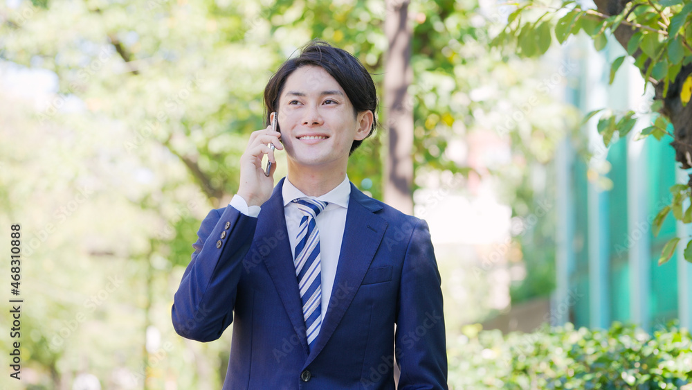 スマホで話す若い男性ビジネスマン