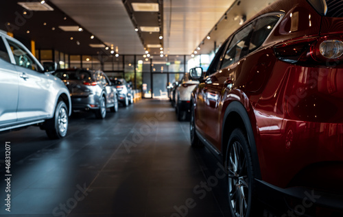 Rearview car parked in luxury showroom. Car dealership office. New car parked in modern showroom. Car for sale and rent business concept. Automobile leasing and insurance concept. Electric automobile. © Artinun