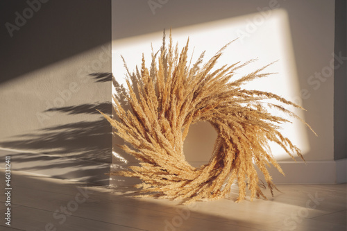 Pampas grass wreath fall interior decotarion in cottagecore style on the floor in sunlight. photo