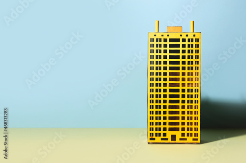 Real estate concept. Colorful yellow apartmant house model on blue background with copy space. photo