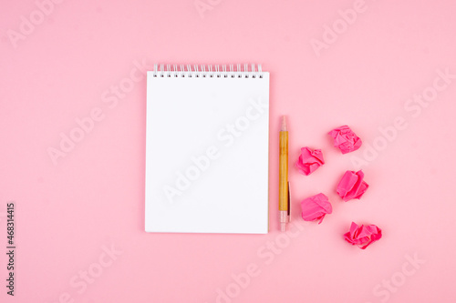 Notepad and pen on pink background in flat lay style. Planning concept for 2022. © Dmitrii