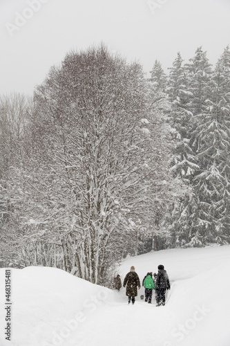 Promeneurs sous la neige sur une route enneigé