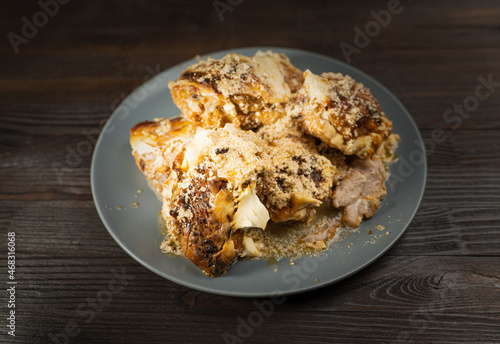 Chicken thighs with sweet paprika in sour cream on a brown wooden table.