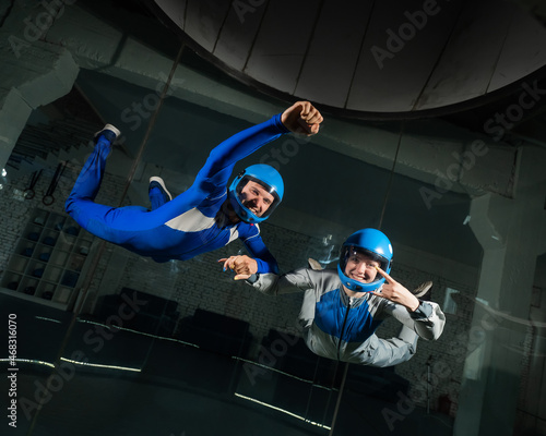 Fototapeta A man and a woman enjoy flying together in a wind tunnel