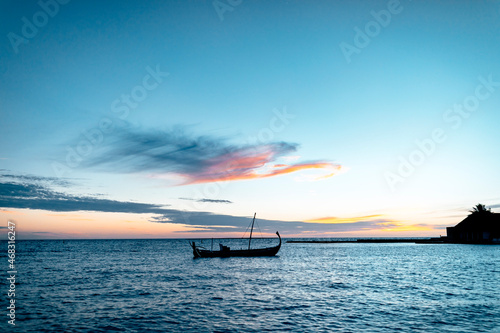 sunset over the sea with traditional sail boat