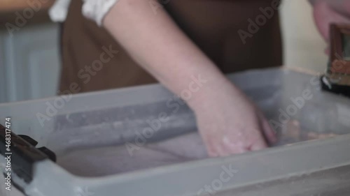 A woman holding a frame for making paper sheets from recycled paper. Selective focus. Household hobby, paper recycling. The concept of zero waste, recycling, ecology.