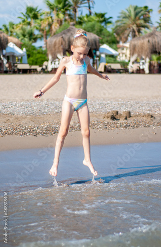 Little girl playing on the beach by the sea © Olena Rudo