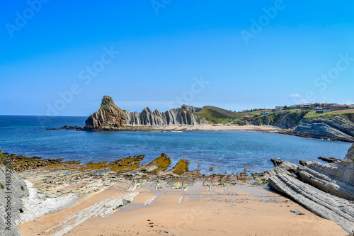 View of Portio beach in Liencres, with its colored sand and rocks. photo