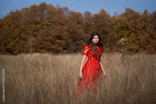 Woman in red dress by the forest