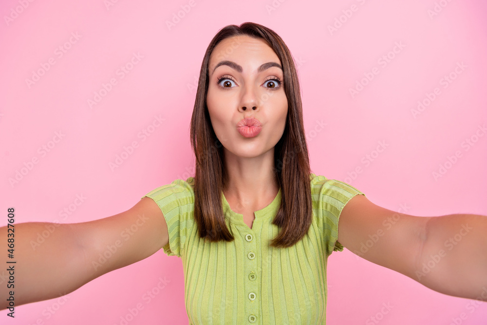 Photo of flirty brunette young lady do selfie blow kiss wear green top isolated on pink color background Photo of flirty brunette young lady do selfie blow kiss wear green top isolated on pink color background