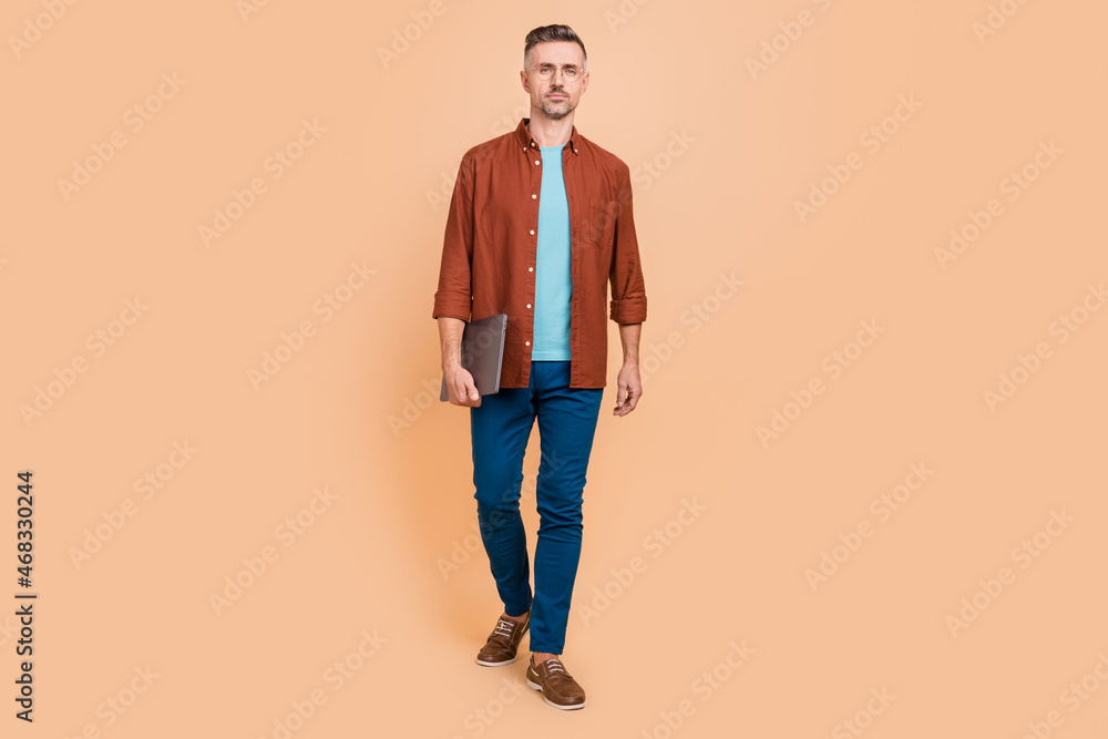 Fototapeta premium Full length photo of bossy middle-aged guy hold netbook go partners conference isolated over pastel color background