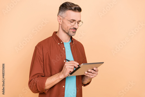 Profile side photo of focused ceo guy use gadget paint stylus screen isolated over beige pastel color background
