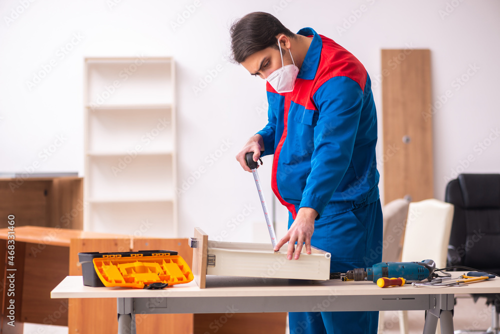Young male carpenter working in the office during pandemic Young male carpenter working in the office during pandemic