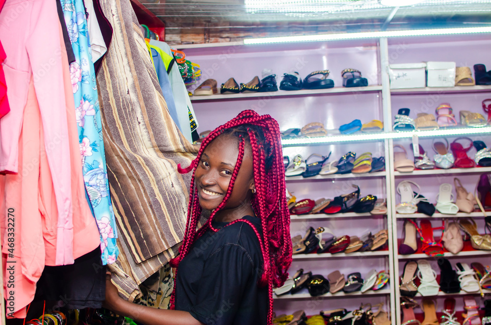 beautiful young african woman shopping for clothes in store