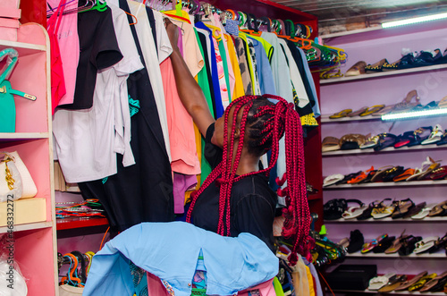 Beautiful woman checking Multi-coloured wardrobe showcase and smiling