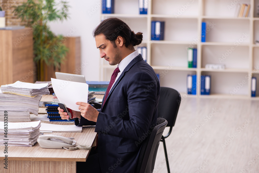 Young male employee unhappy with excessive work Young male employee unhappy with excessive work