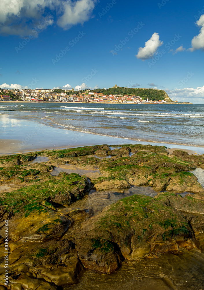 The rock pools in the South Bay, Scarborough, North Yorkshire. Across the sands is the harbour, headland and old town.