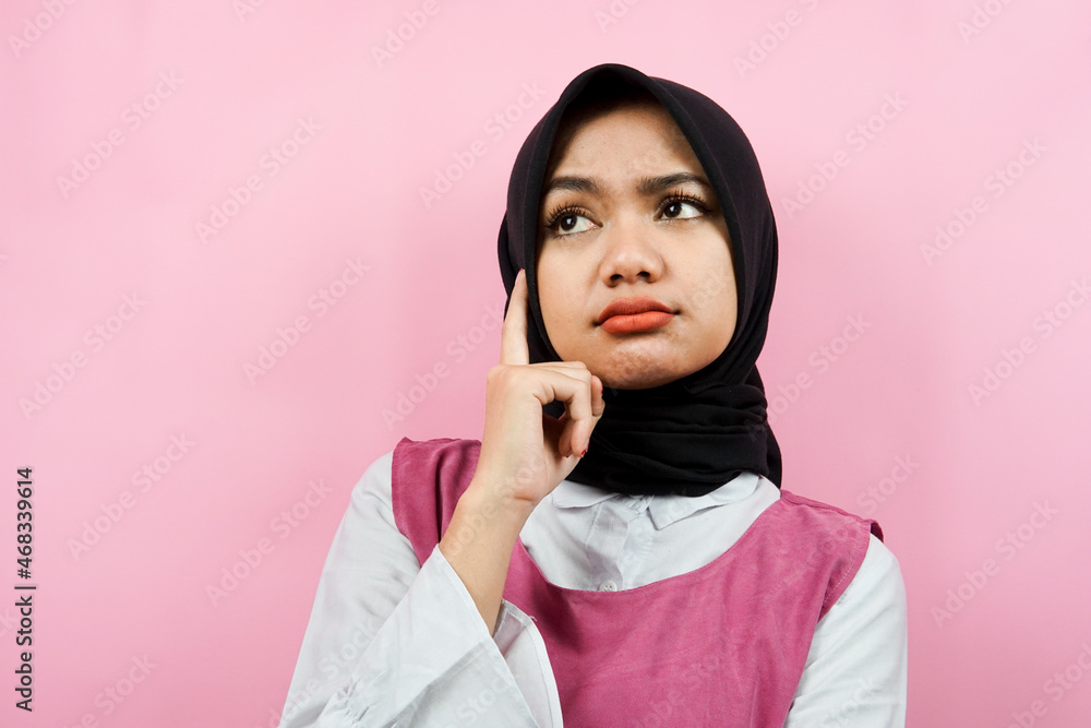 Closeup of beautiful young Muslim woman thinking, looking for ideas, looking at empty space, presenting something, isolated Closeup of beautiful young Muslim woman thinking, looking for ideas, looking at empty space, presenting something, isolated