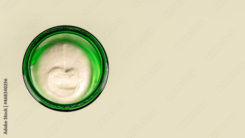 Body cream or face cream in a green jar on a green background. The concept of freshness and naturalness of cosmetics Body cream or face cream in a green jar on a green background. The concept of freshness and naturalness of cosmetics