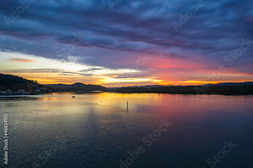 Sunrise waterscape with colourful cloud covered sky