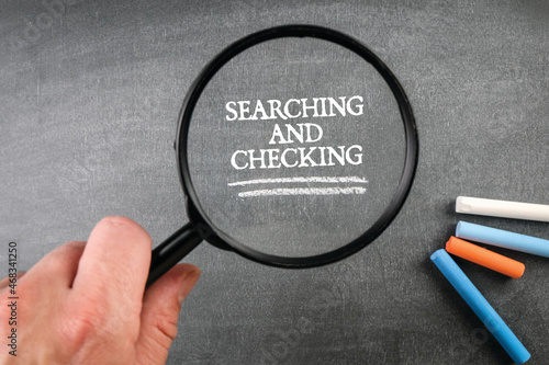 Searching and Checking. Magnifying glass in a man's hand