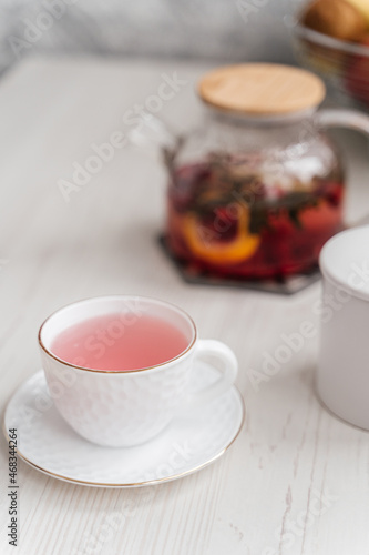 cup and teapot with rose tea on the table