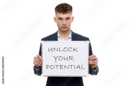 A businessman shows an inscription: UNLOCK YOUR POTENTIAL